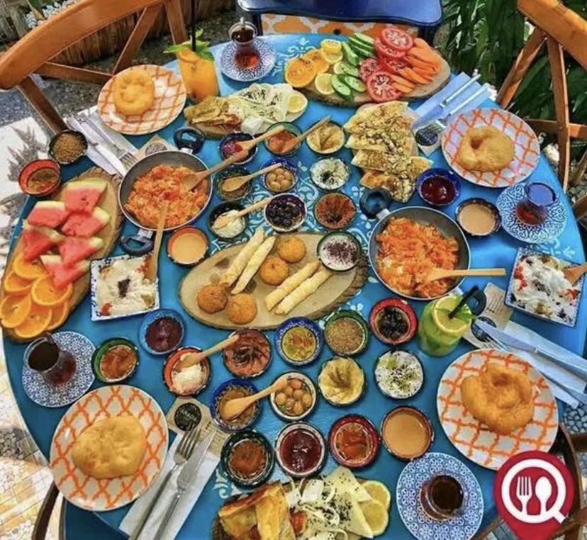 raditional Turkish breakfast in Cappadocia with cheeses, olives, bread, honey, and tea served on a Cave hotel rooftop terrace.